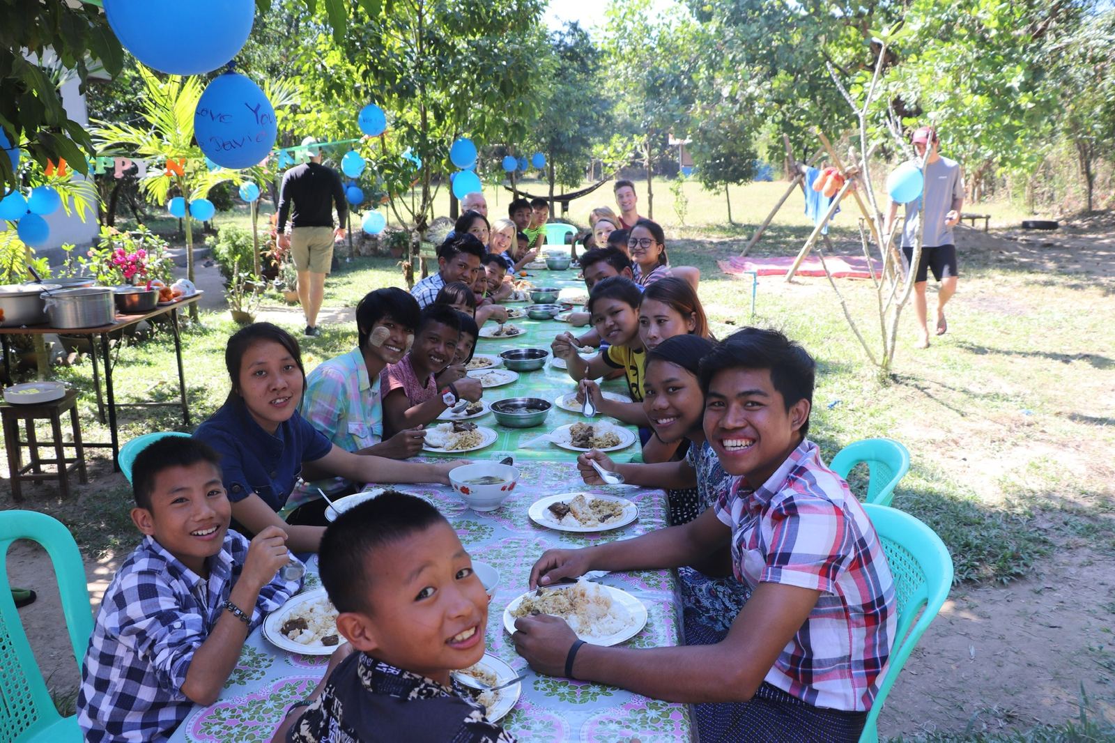 Children sharing a meal together at a long outdoor table
